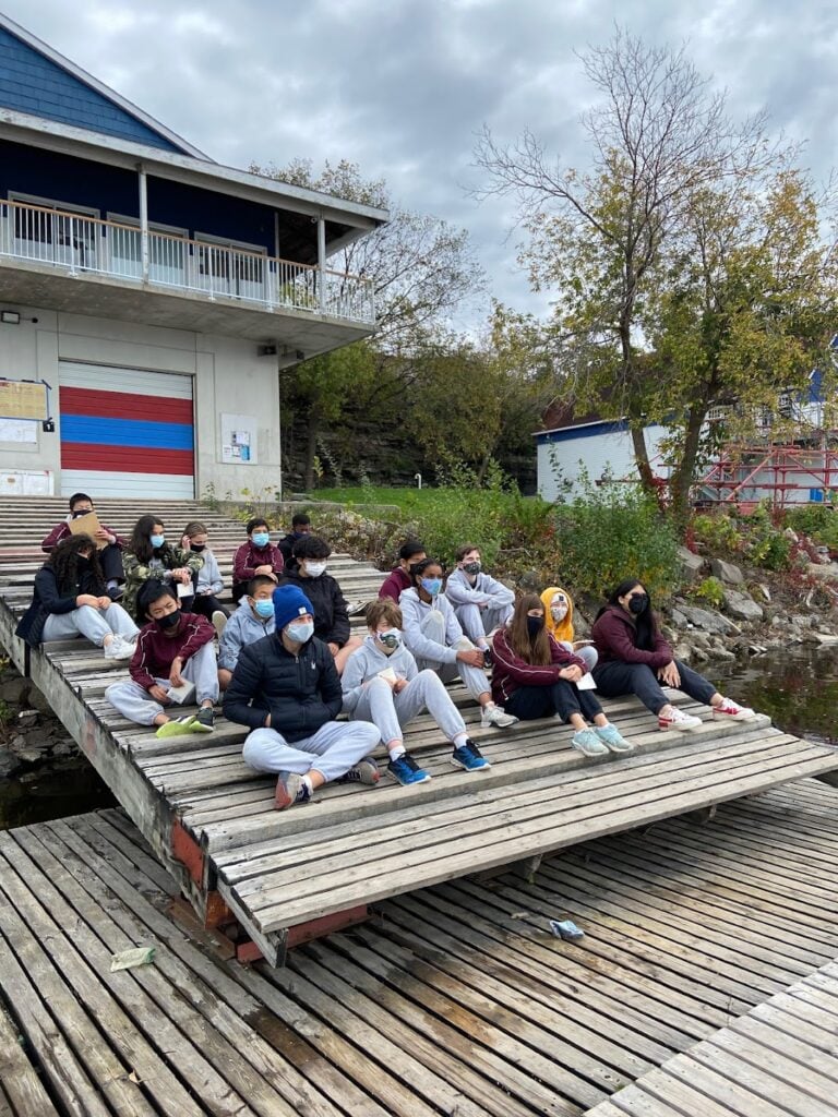 Students sitting near the water during the Ashbury college excursion.
