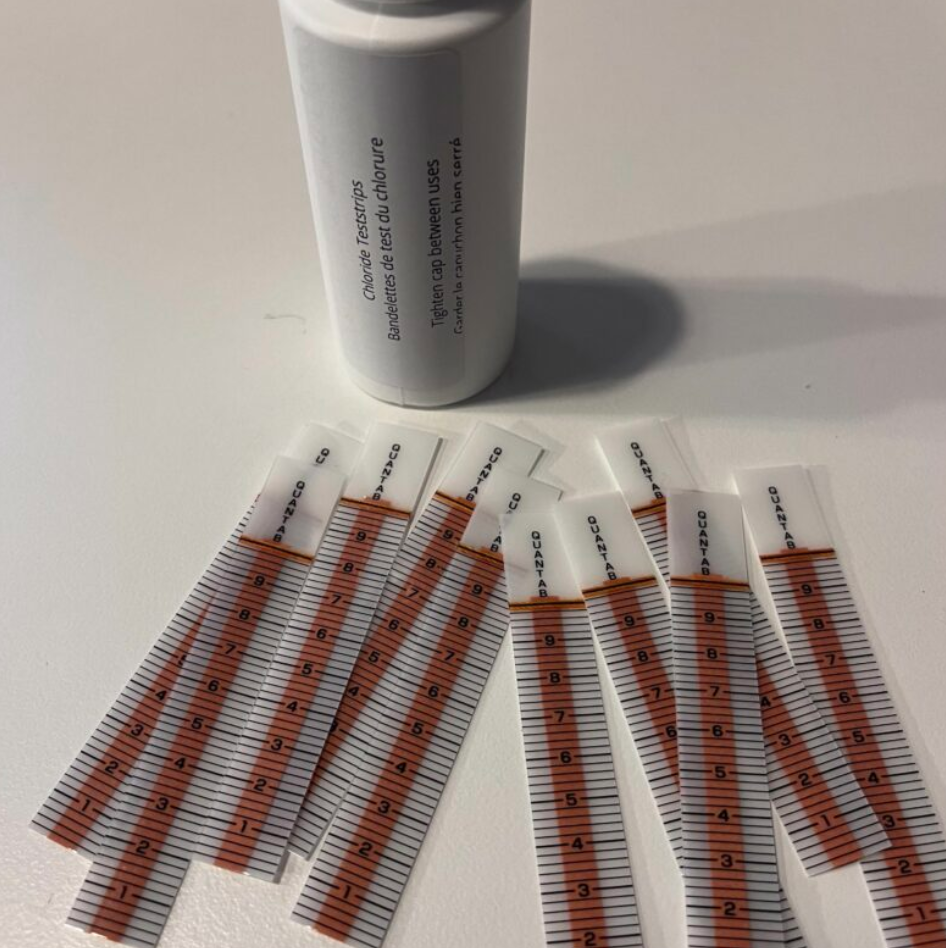 Image of chloride teststrips laid out with bottle.  